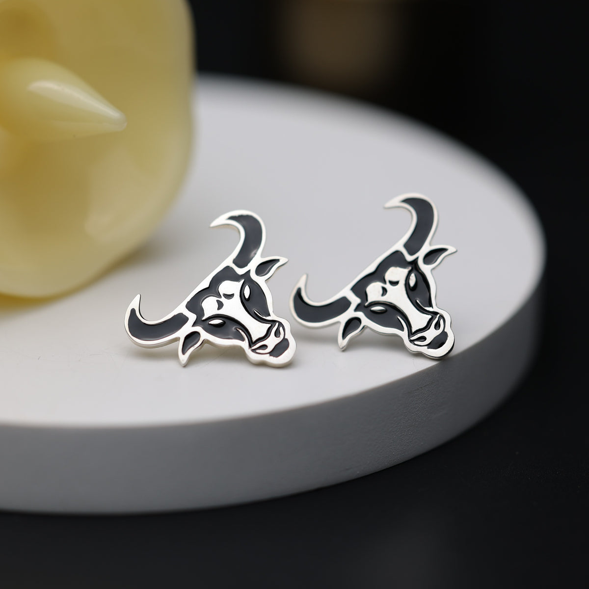 These Cow/Bull Stud Earrings feature a detailed black-and-white cow face design with contrasting enamel-style detailing making a meaningful gift for him or her.