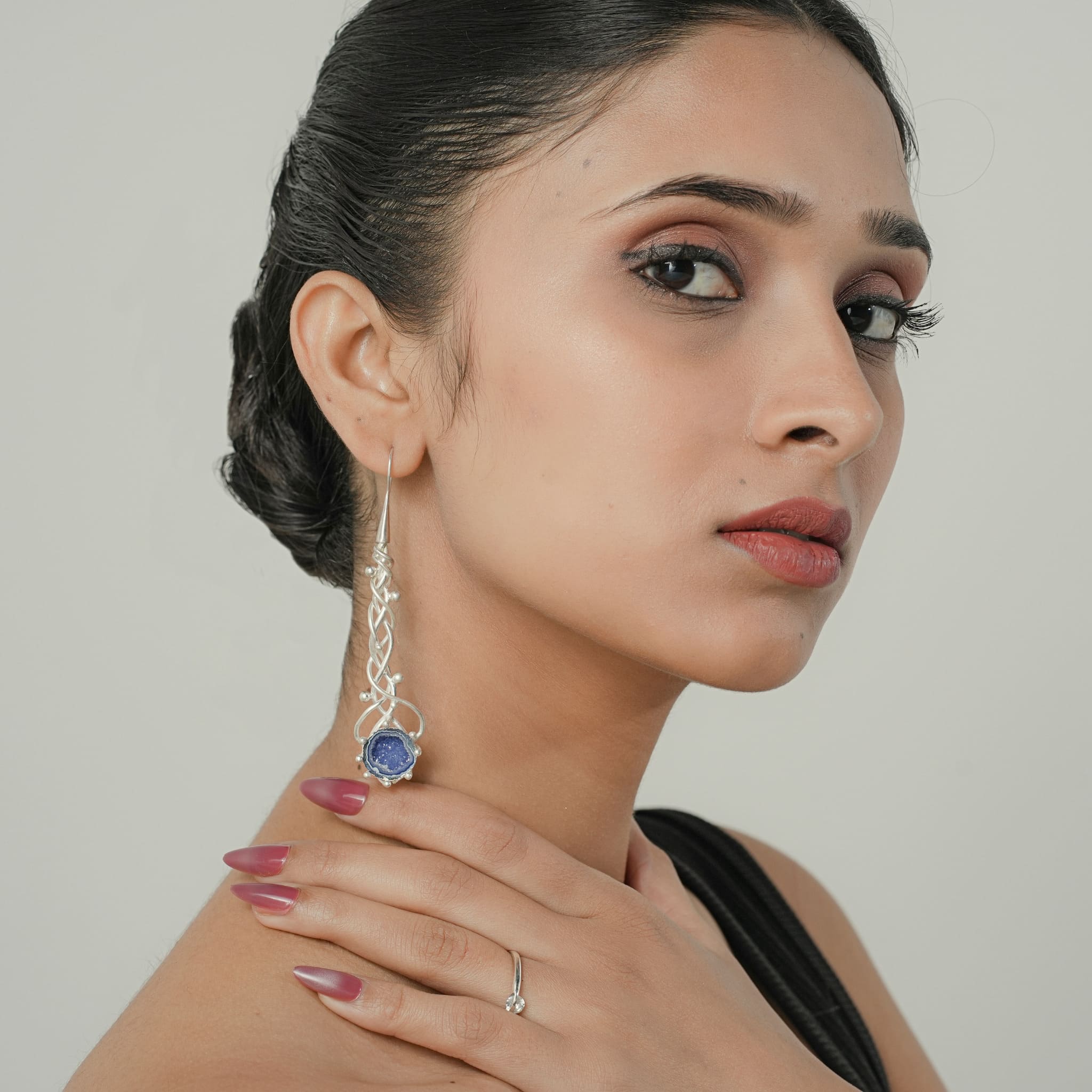 Model wearing long silver geode drop earrings
