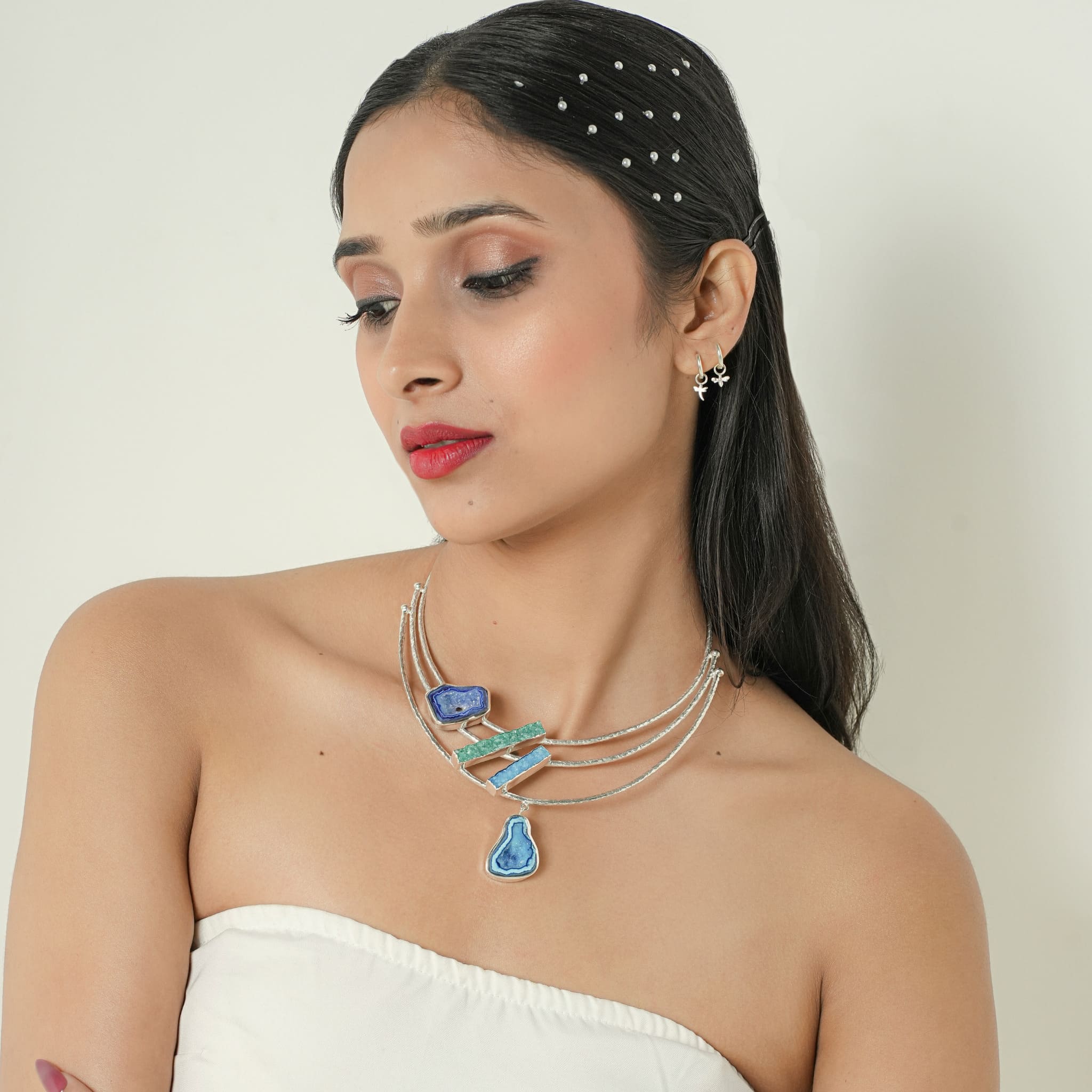 Model wearing layered silver necklace with agate and druzy geode stones