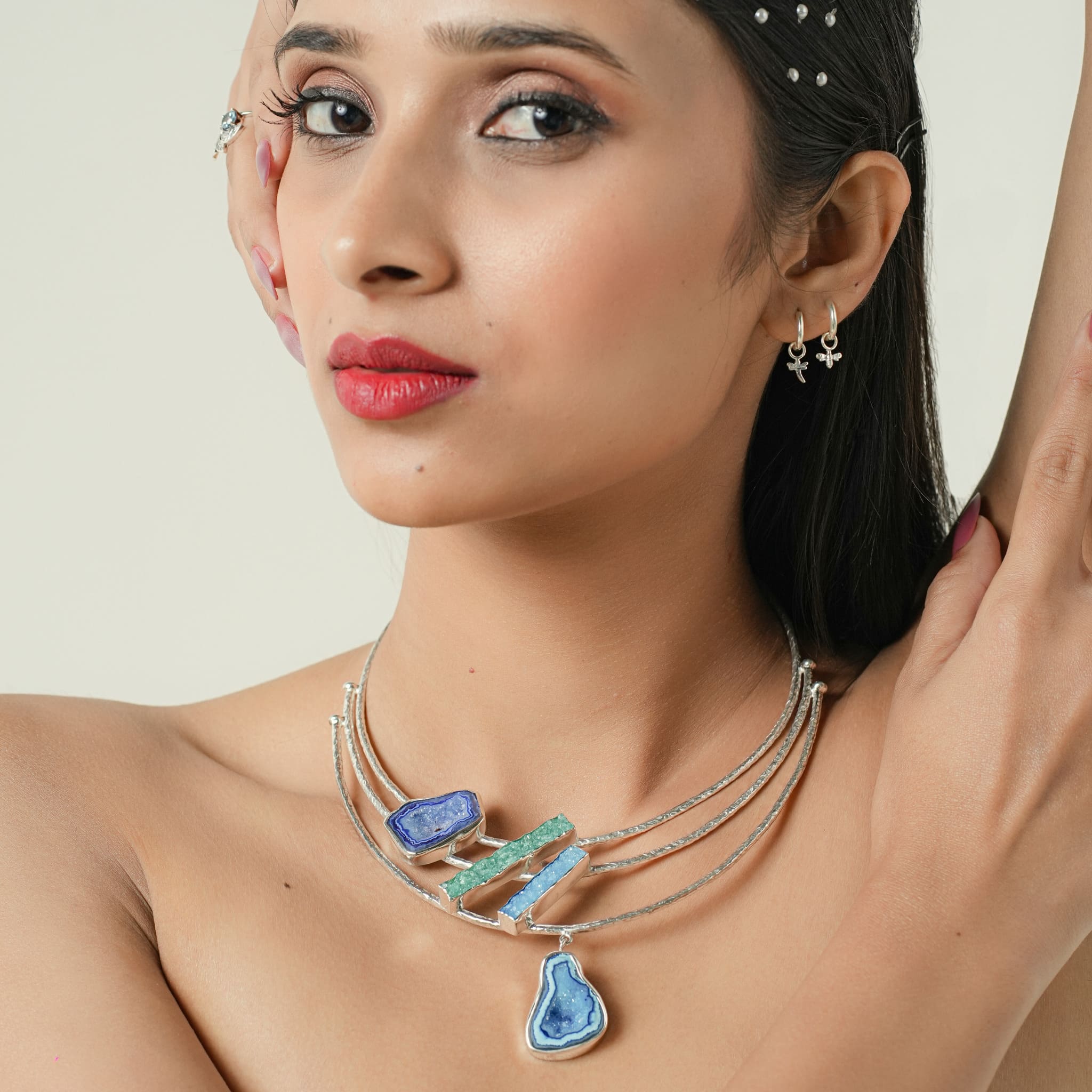 Model wearing layered silver necklace with agate and druzy geode stones