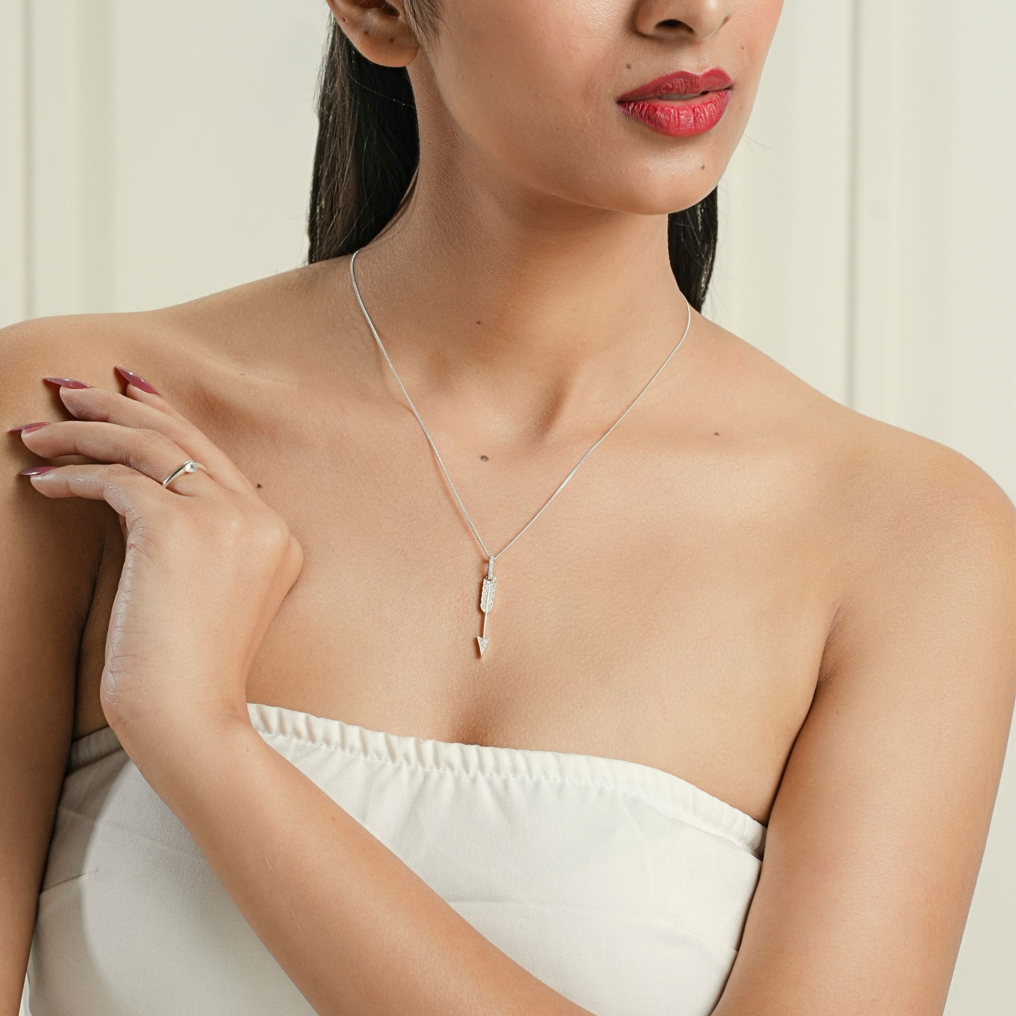 Model wearing silver arrow pendant with CZ stones