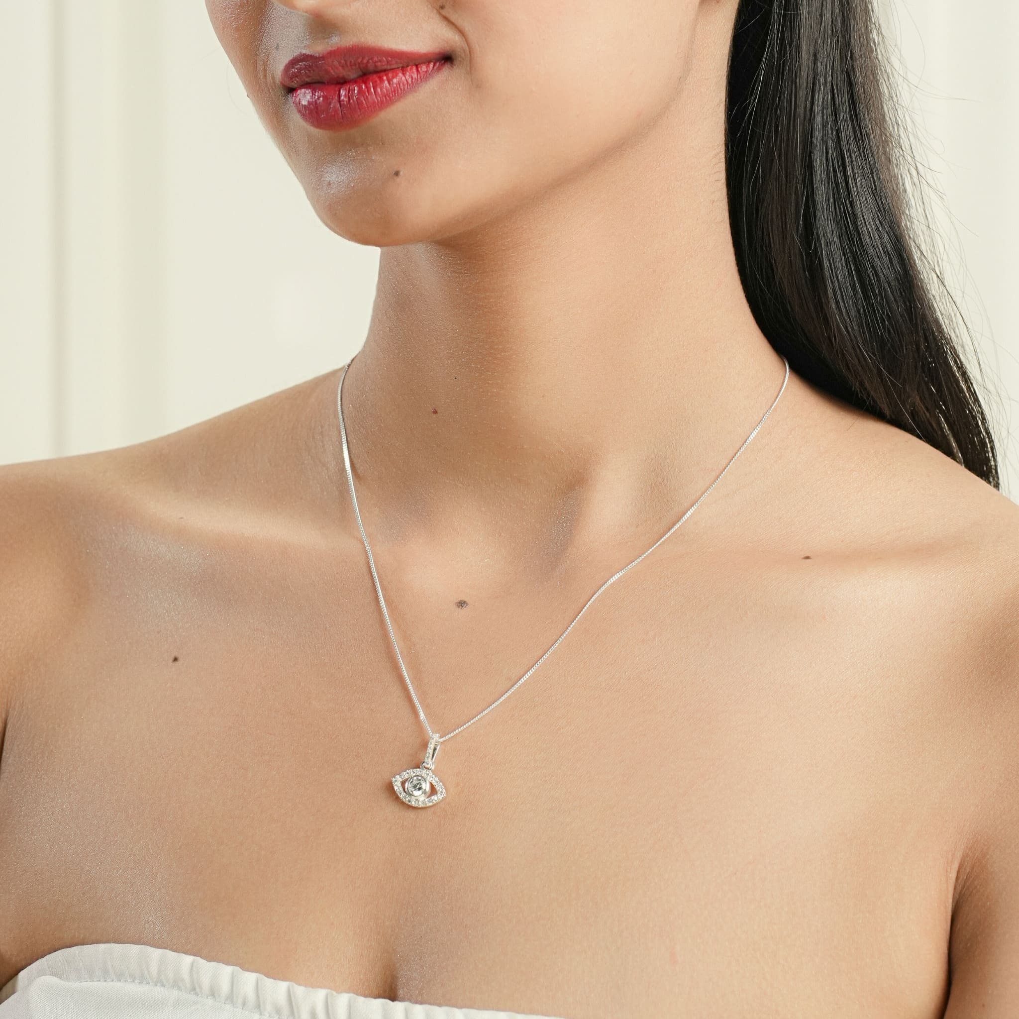 Model wearing silver evil eye pendant 