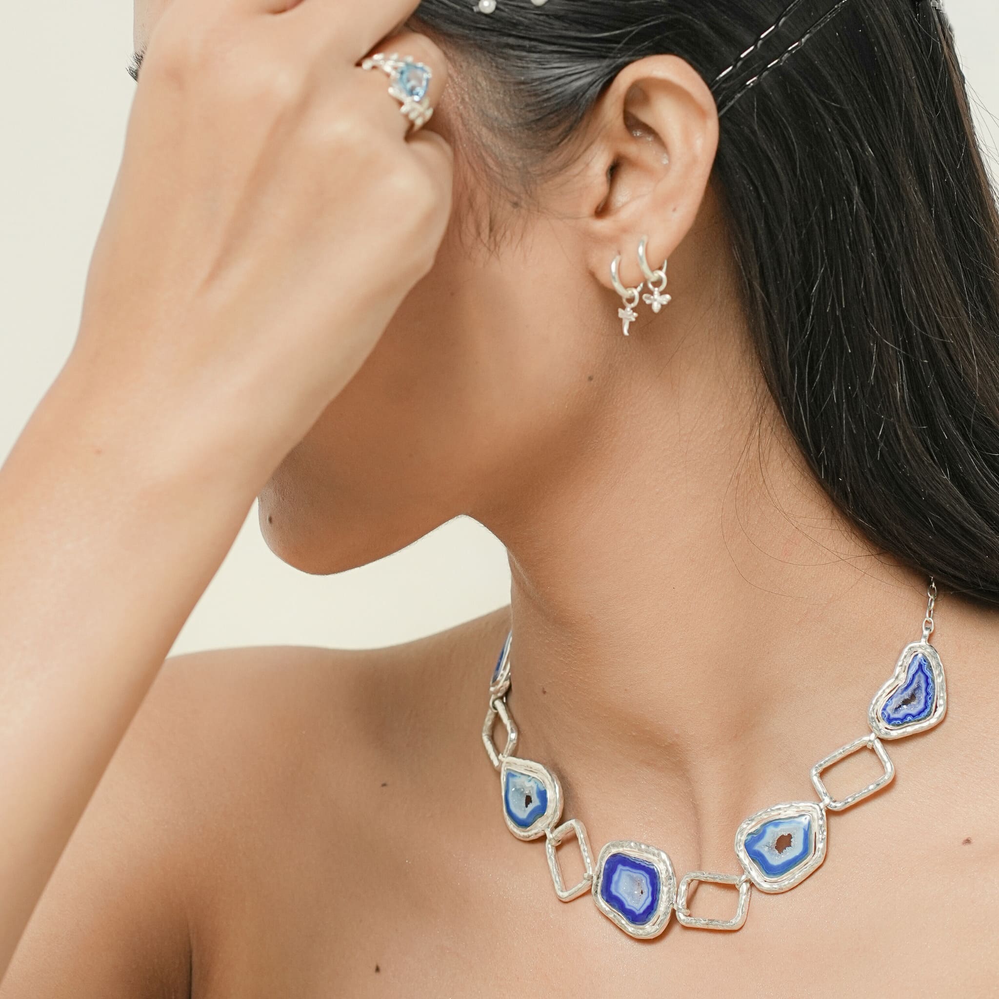 Model wearing silver agate band necklace with geometric links
